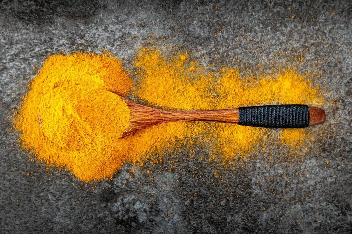 Various anti-inflammatory spices in small bowls including turmeric, ginger, and cinnamon